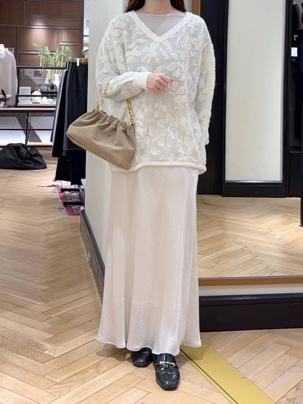 グレー系のTシャツ/カットソー、ブラック系のローファー、ホワイト系のスカートを着用したレディースの冬コーディネートの1枚目の写真