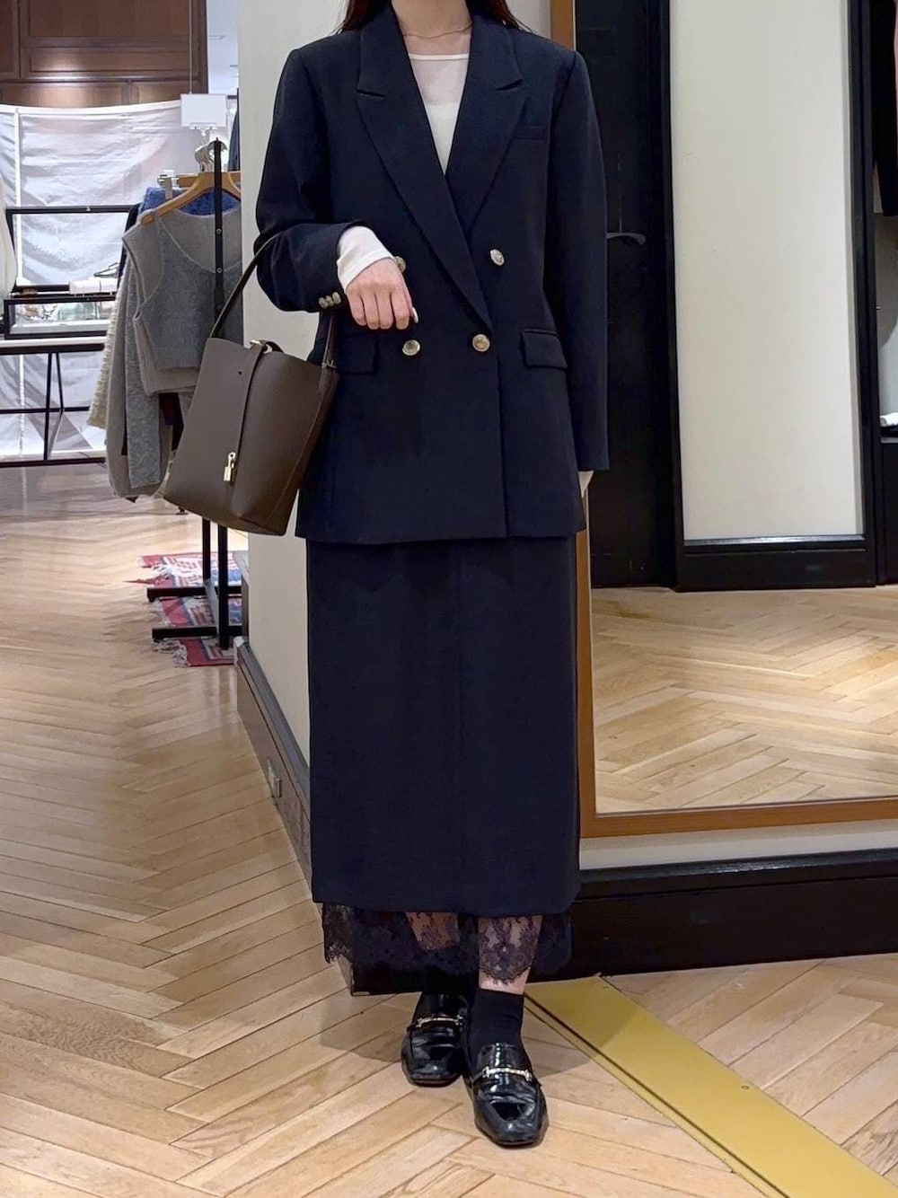 ブラック系のローファー、ブルー系のスカート、ブルー系のテーラードジャケットを着用したレディースの冬コーディネートの1枚目の写真