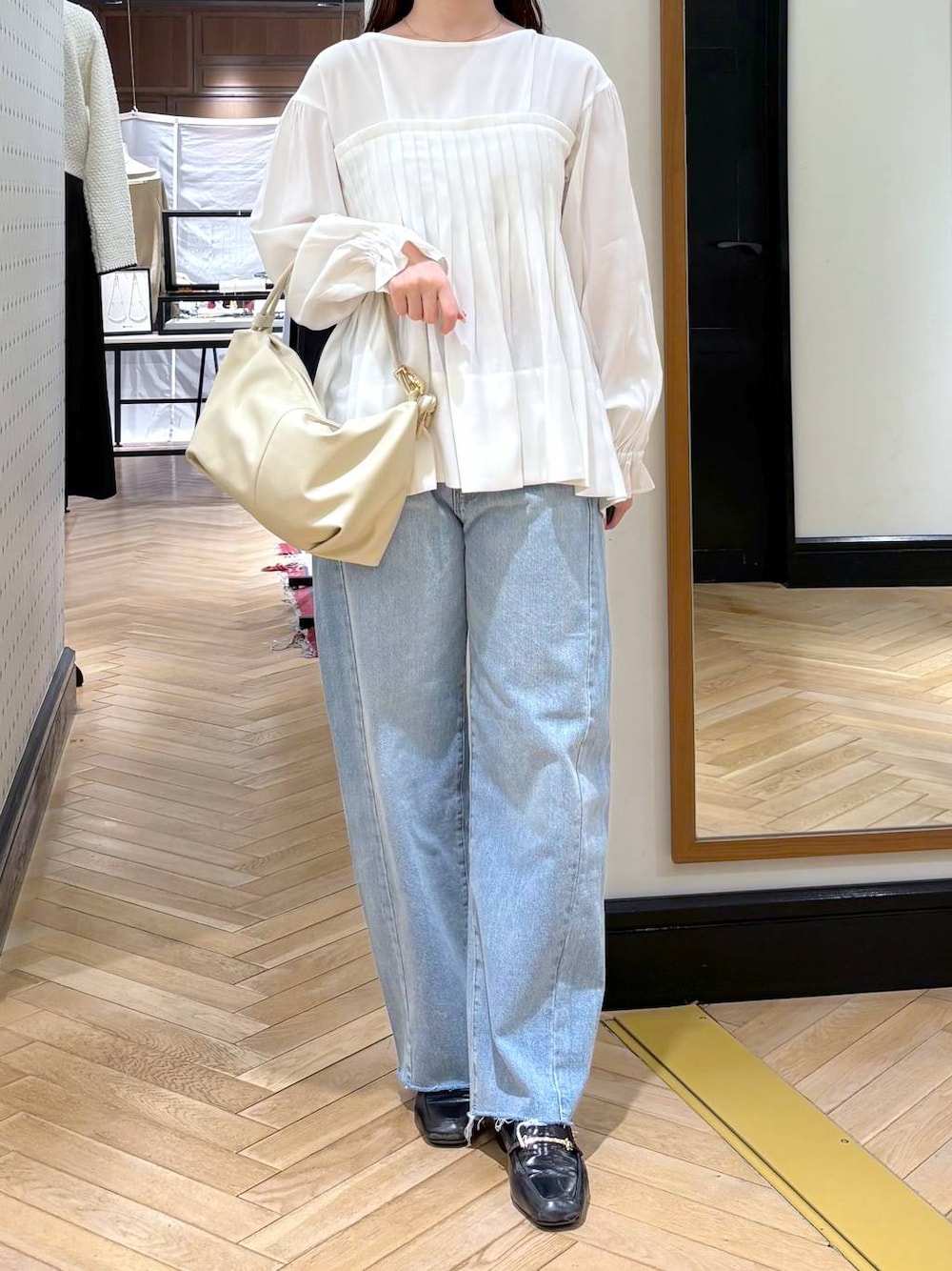 ブラック系のローファー、ブルー系のデニムパンツ、ホワイト系のシャツ/ブラウスを着用したレディースの冬コーディネートの1枚目の写真