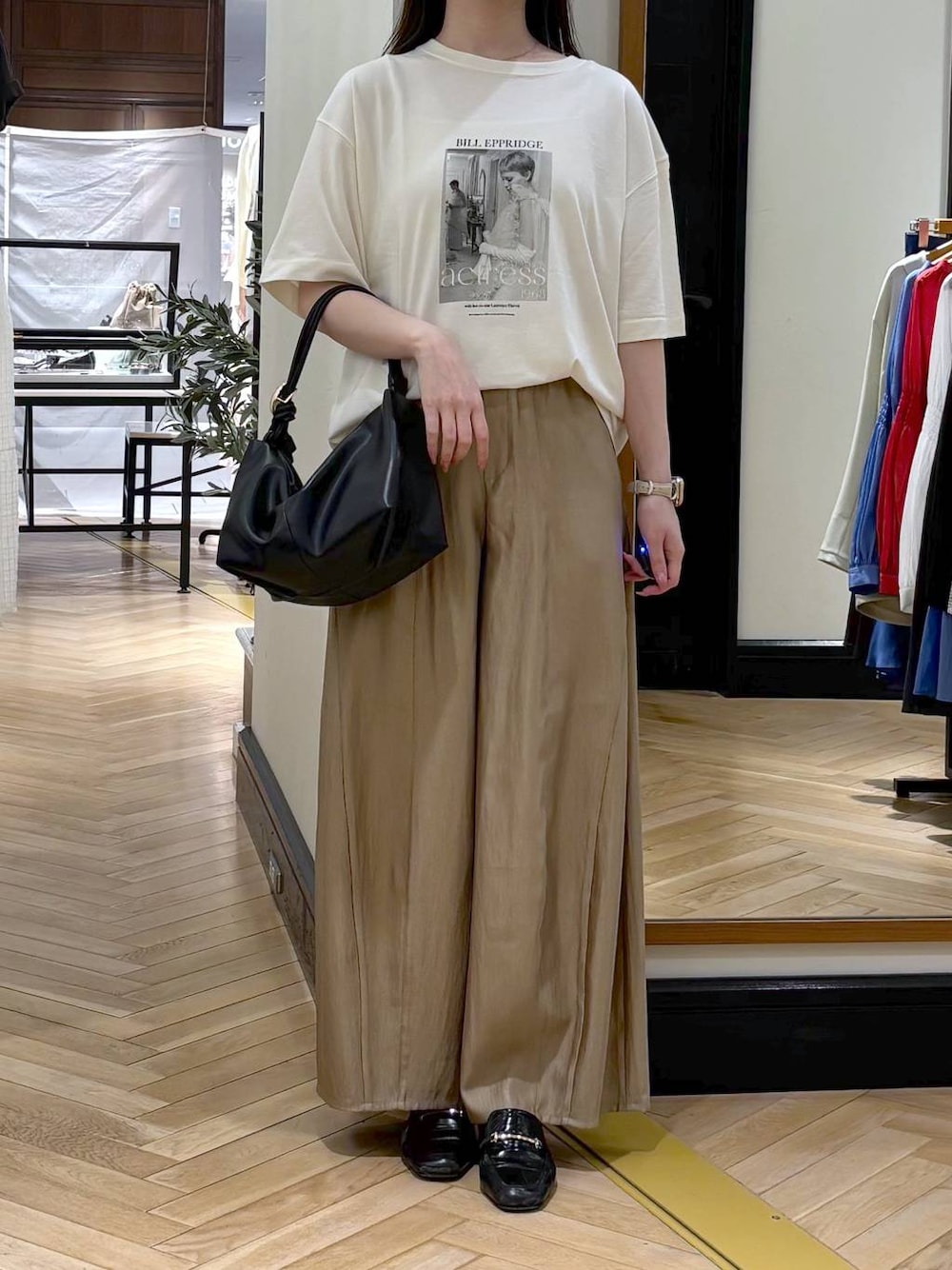 ブラック系のローファー、ベージュ系のその他パンツ、ブラック系のショルダーバッグを着用したレディースの春コーディネートの1枚目の写真