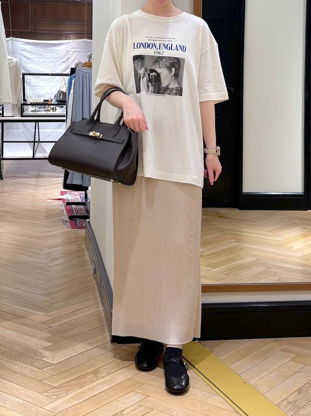 ホワイト系のスカート、ブラック系のショルダーバッグ、ブルー系のTシャツ/カットソーを着用したレディースの春コーディネートの1枚目の写真