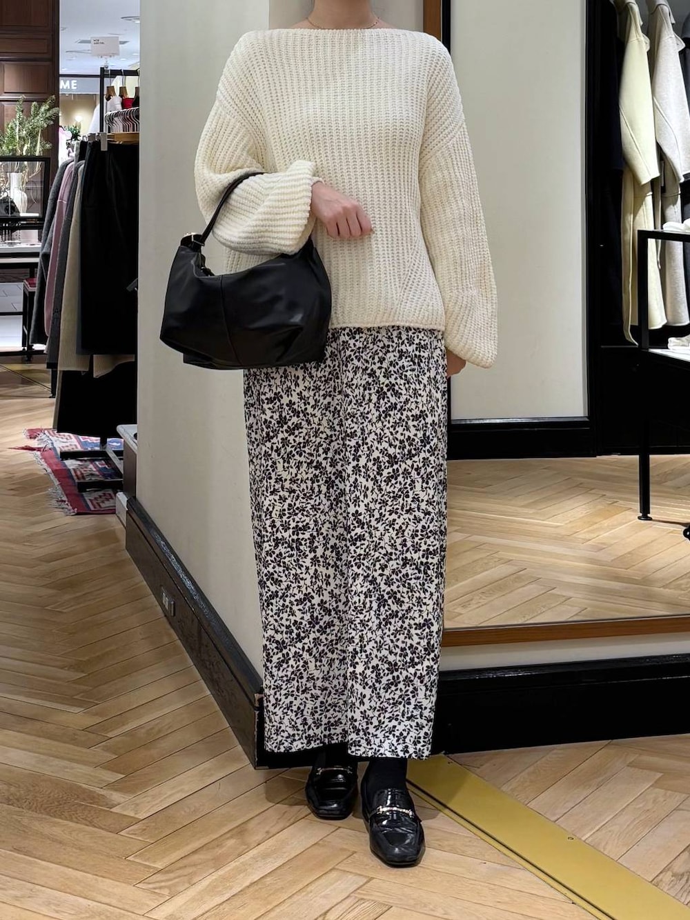 ブラック系のローファー、ホワイト系のニット/セーター、ブラック系のショルダーバッグを着用したレディースの冬コーディネートの1枚目の写真