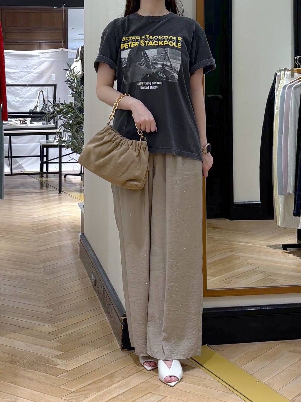 ベージュ系のショルダーバッグ、グレー系のTシャツ/カットソー、ホワイト系のサンダルを着用したレディースの春コーディネートの1枚目の写真