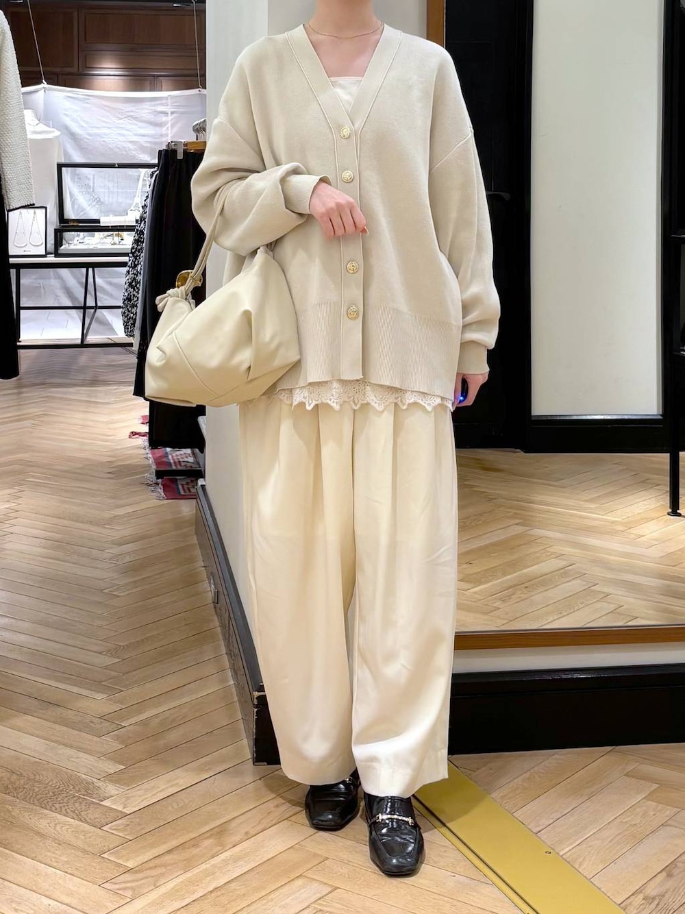 ホワイト系のスラックス、ブラック系のローファー、ホワイト系のカーディガン/ボレロを着用したレディースの冬コーディネートの1枚目の写真