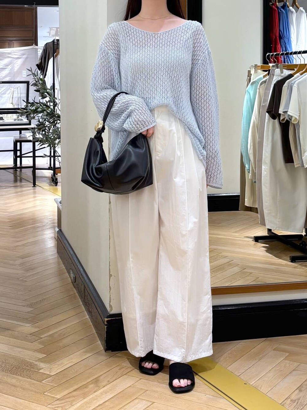 ブラック系のショルダーバッグ、ホワイト系のその他パンツ、ブルー系のニット/セーターを着用したレディースの春コーディネートの1枚目の写真