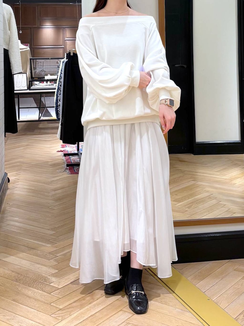 ブラック系のローファー、ホワイト系のスカート、ホワイト系のスウェットを着用したレディースの冬コーディネートの1枚目の写真