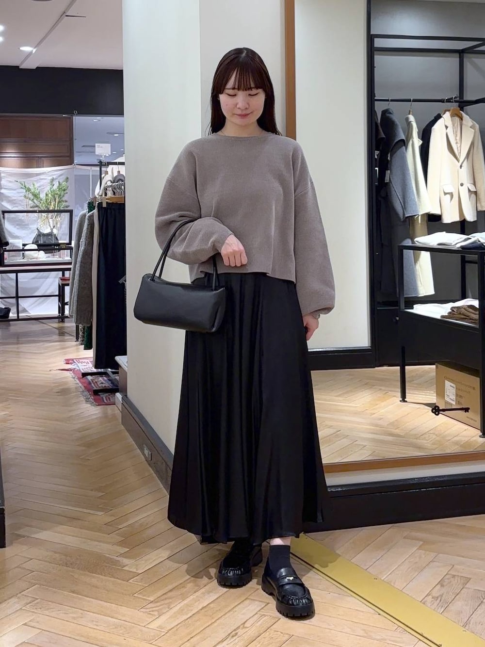 ベージュ系のニット/セーター、ブラック系のローファー、ブラック系のスカートを着用したレディースの冬コーディネートの1枚目の写真