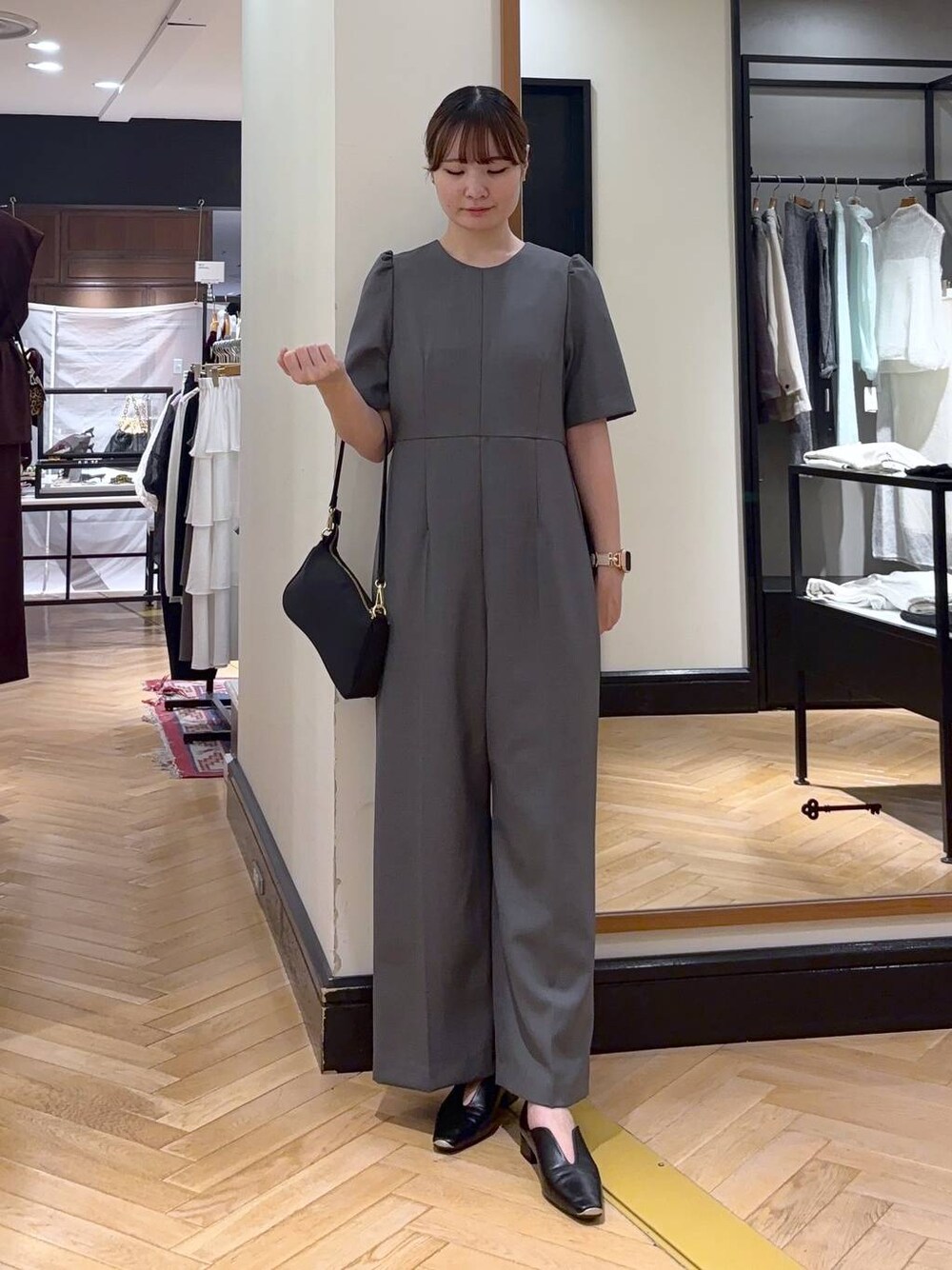 ブラック系のパンプス、ブラック系のショルダーバッグ、グレー系のつなぎ/オールインワンを着用したレディースの秋コーディネートの1枚目の写真