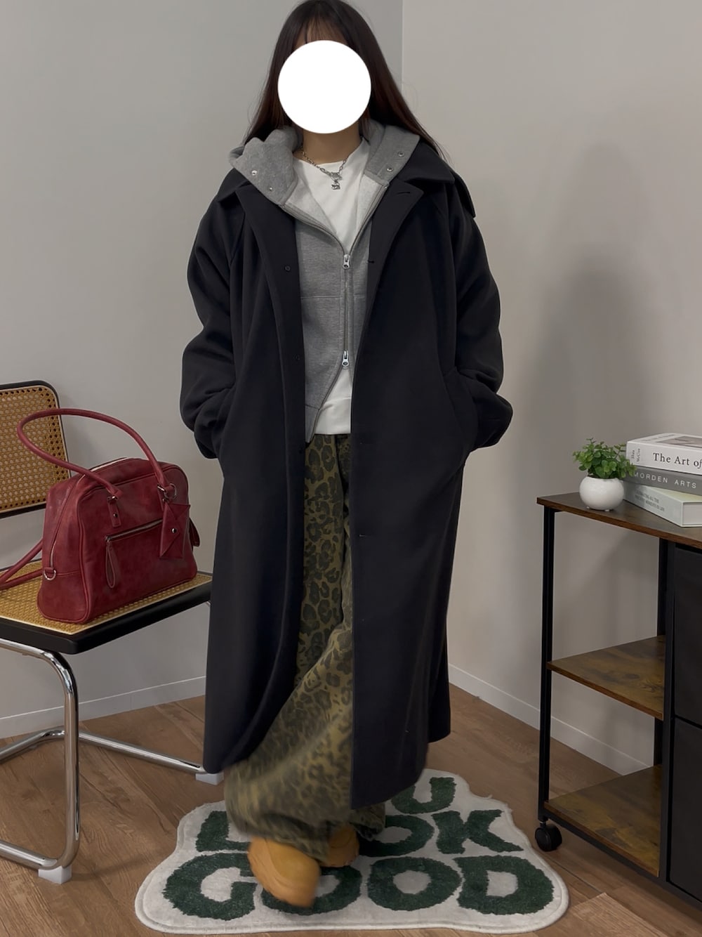 ブラック系のチェスターコート、グレー系のパーカー、ベージュ系のカーゴパンツを着用したレディースの冬コーディネートの1枚目の写真