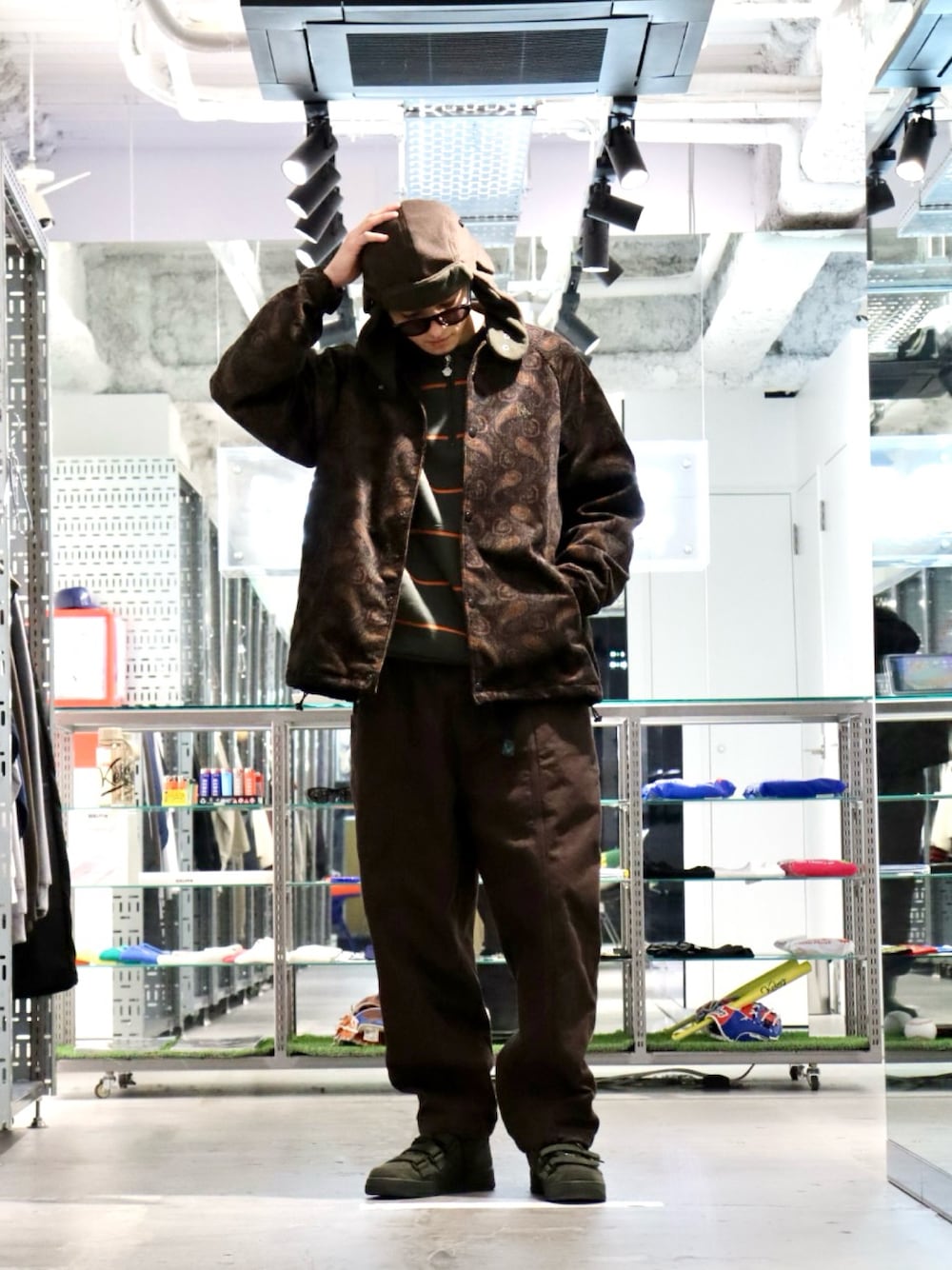 グリーン系のスウェット、ブラウン系のブルゾン、ブラウン系のハットを着用したメンズの冬コーディネートの1枚目の写真