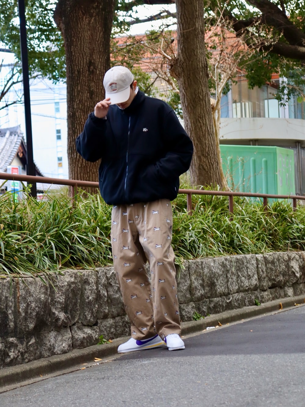 ブラック系のナイロンジャケット、ブラック系のスウェット、ベージュ系のチノパンツを着用したメンズの冬コーディネートの1枚目の写真