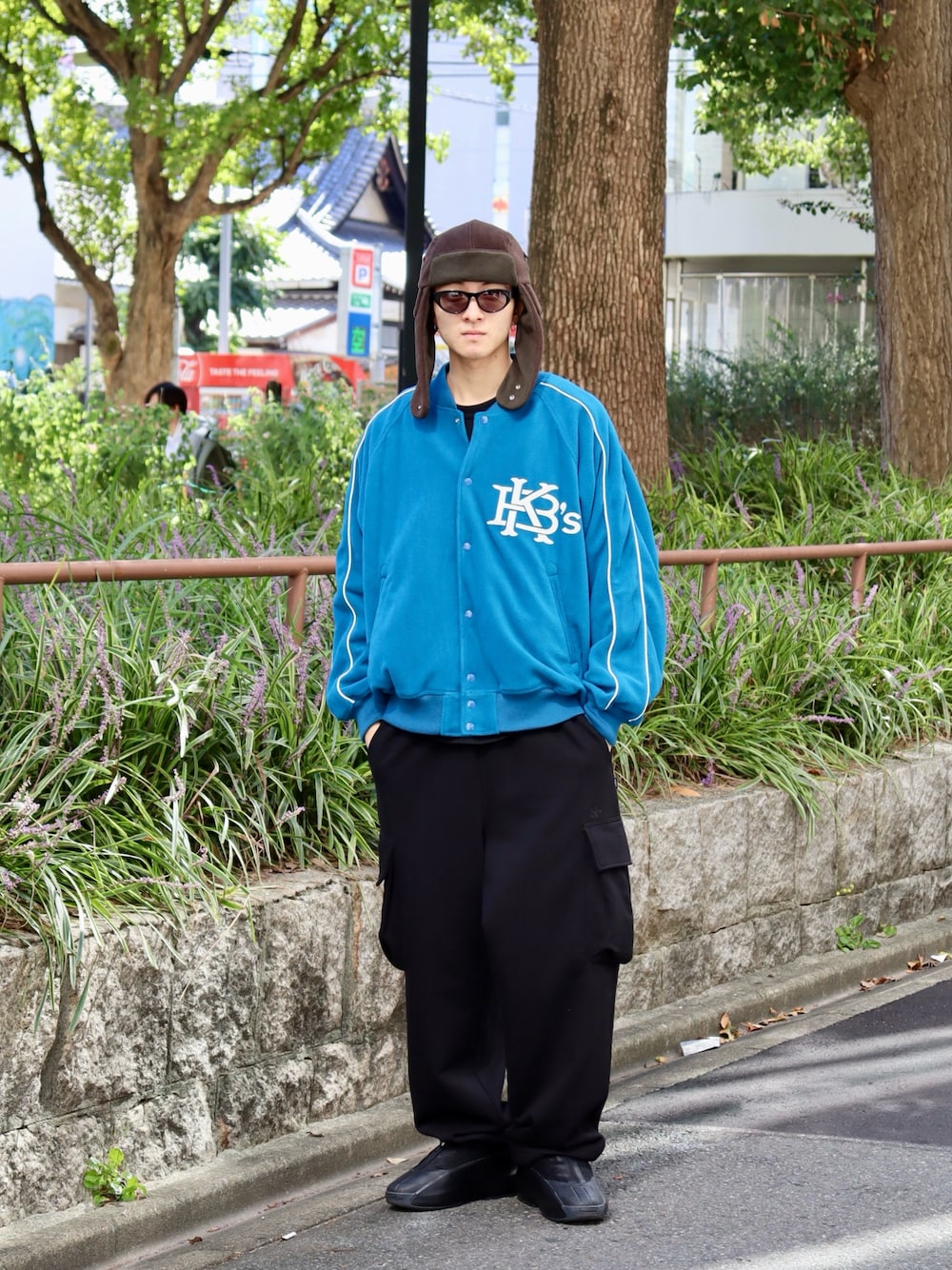 ブルー系のスタジャン、ブラック系のスウェットパンツ、ブラック系のTシャツ/カットソーを着用したメンズの秋コーディネートの1枚目の写真