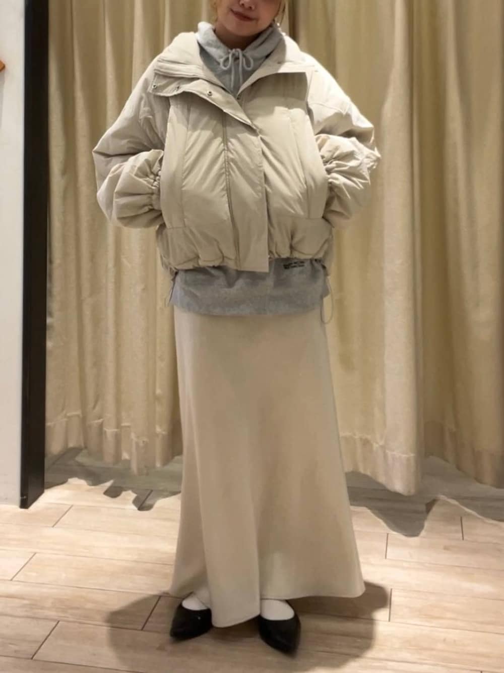 ホワイト系のその他アウター、ホワイト系のスカート、グレー系のスウェットを着用したレディースの秋コーディネートの1枚目の写真