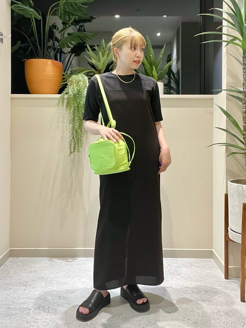 ブラック系のワンピース、グリーン系のショルダーバッグ、ブラック系のサンダルを着用したレディースの夏コーディネートの1枚目の写真