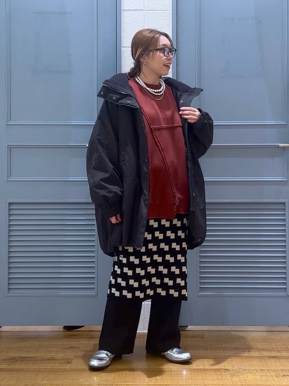 ブラック系のその他アウター、シルバー系のローファー、ブラック系のスカートを着用したレディースの冬コーディネートの1枚目の写真