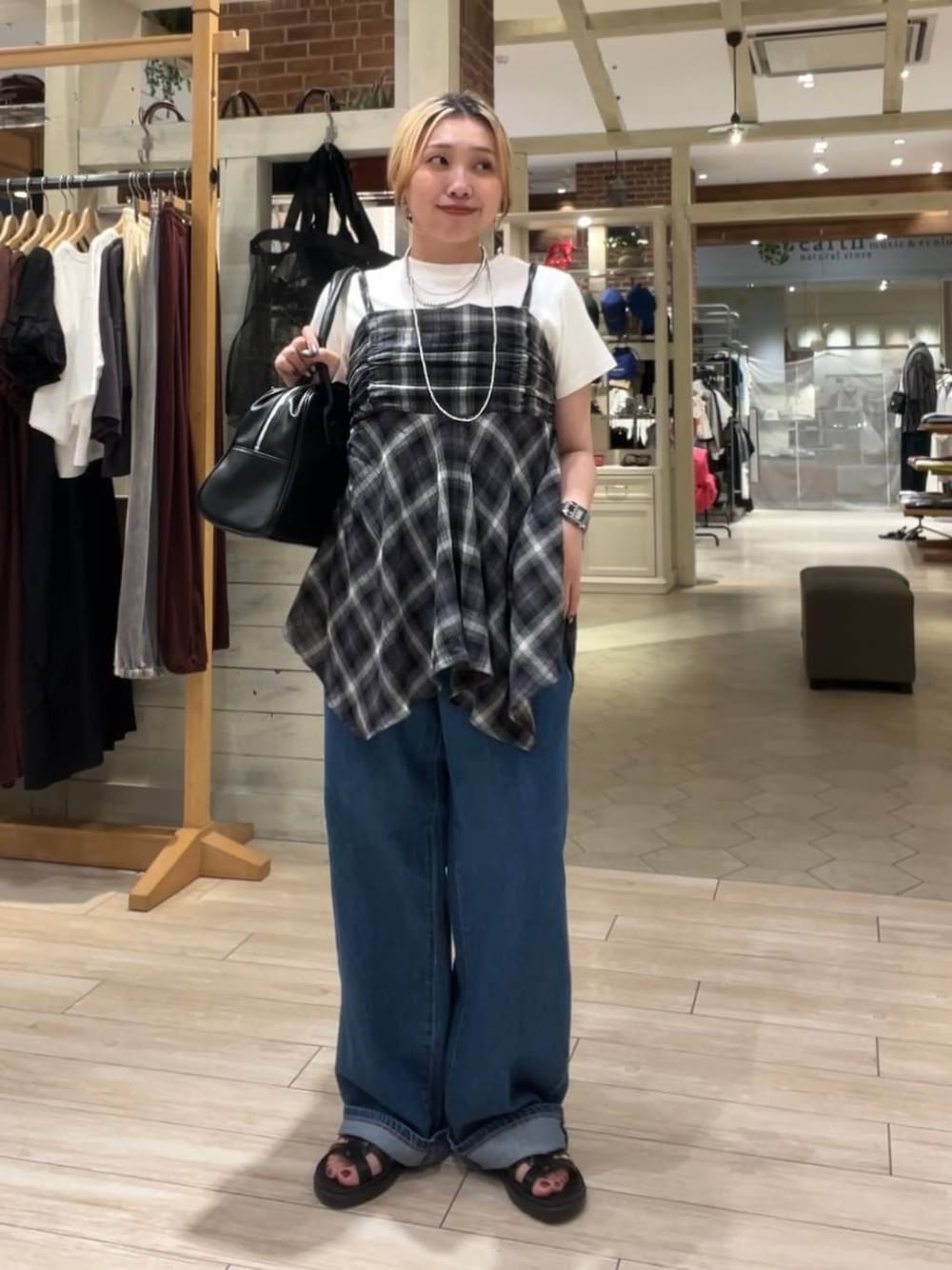 ホワイト系のTシャツ/カットソー、ブラック系のサンダル、ブルー系のデニムパンツを着用したレディースの夏コーディネートの1枚目の写真