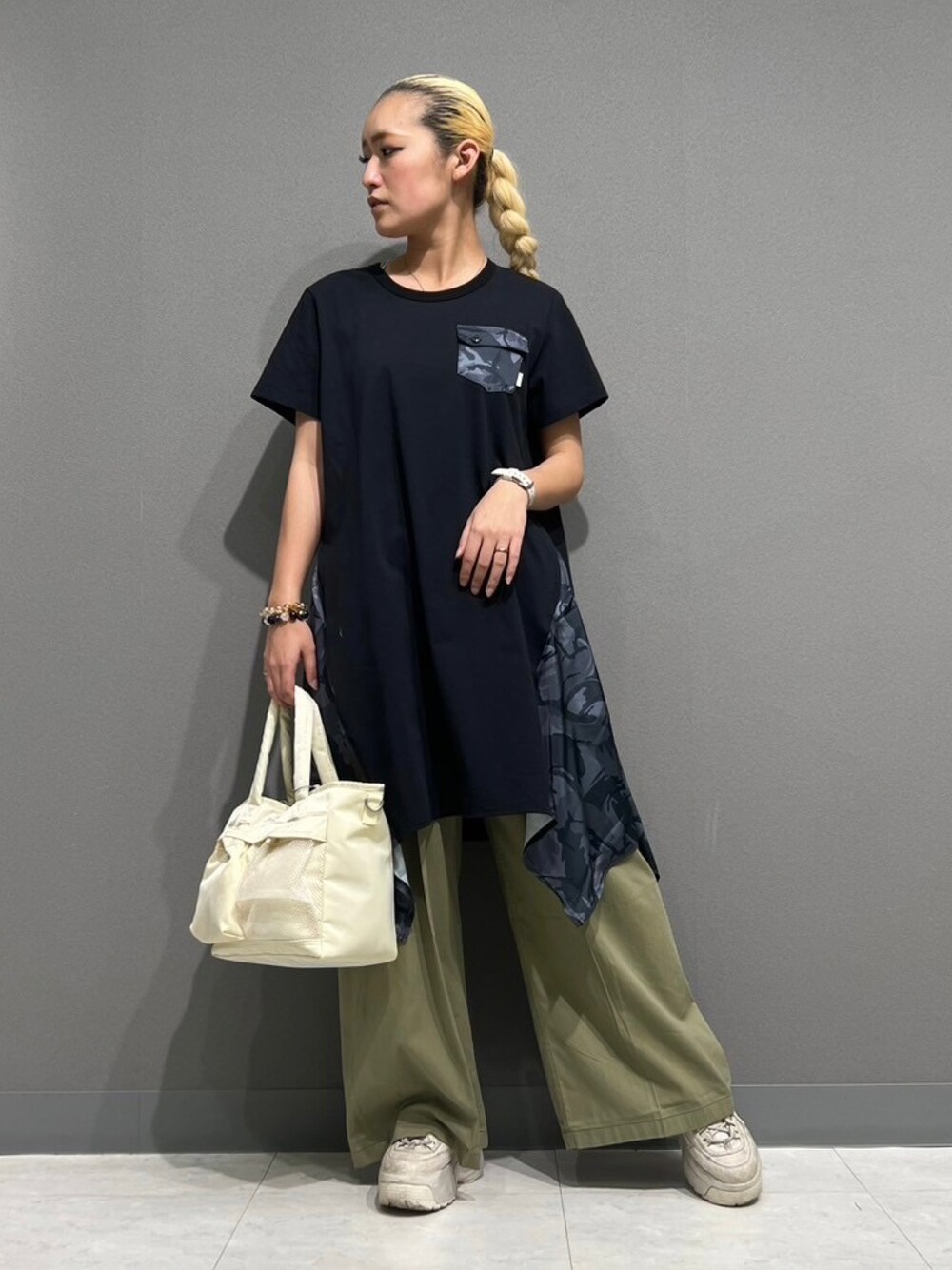 ブルー系のその他パンツ、グリーン系のトートバッグ、ブラック系のワンピースを着用したレディースの春コーディネートの1枚目の写真