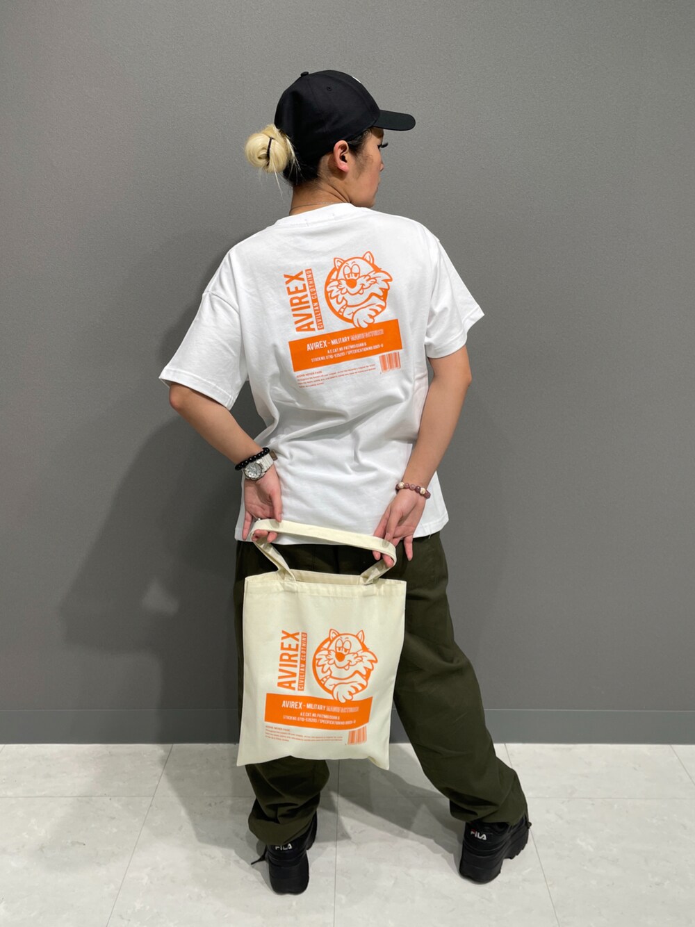 ホワイト系のTシャツ/カットソー、グリーン系のその他パンツ、ホワイト系のトートバッグを着用したレディースの春コーディネートの1枚目の写真