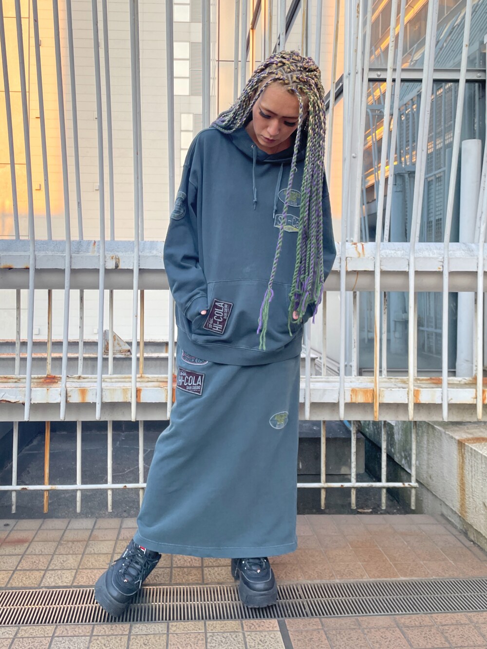 グリーン系のスカート、グリーン系のパーカーを着用したレディースの冬コーディネートの1枚目の写真