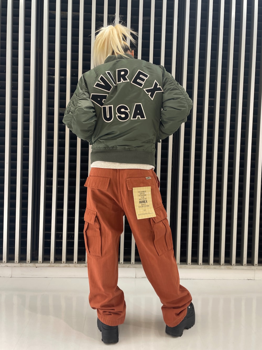 グリーン系のMA-1、レッド系のカーゴパンツ、ベージュ系のスウェットを着用したレディースの冬コーディネートの1枚目の写真