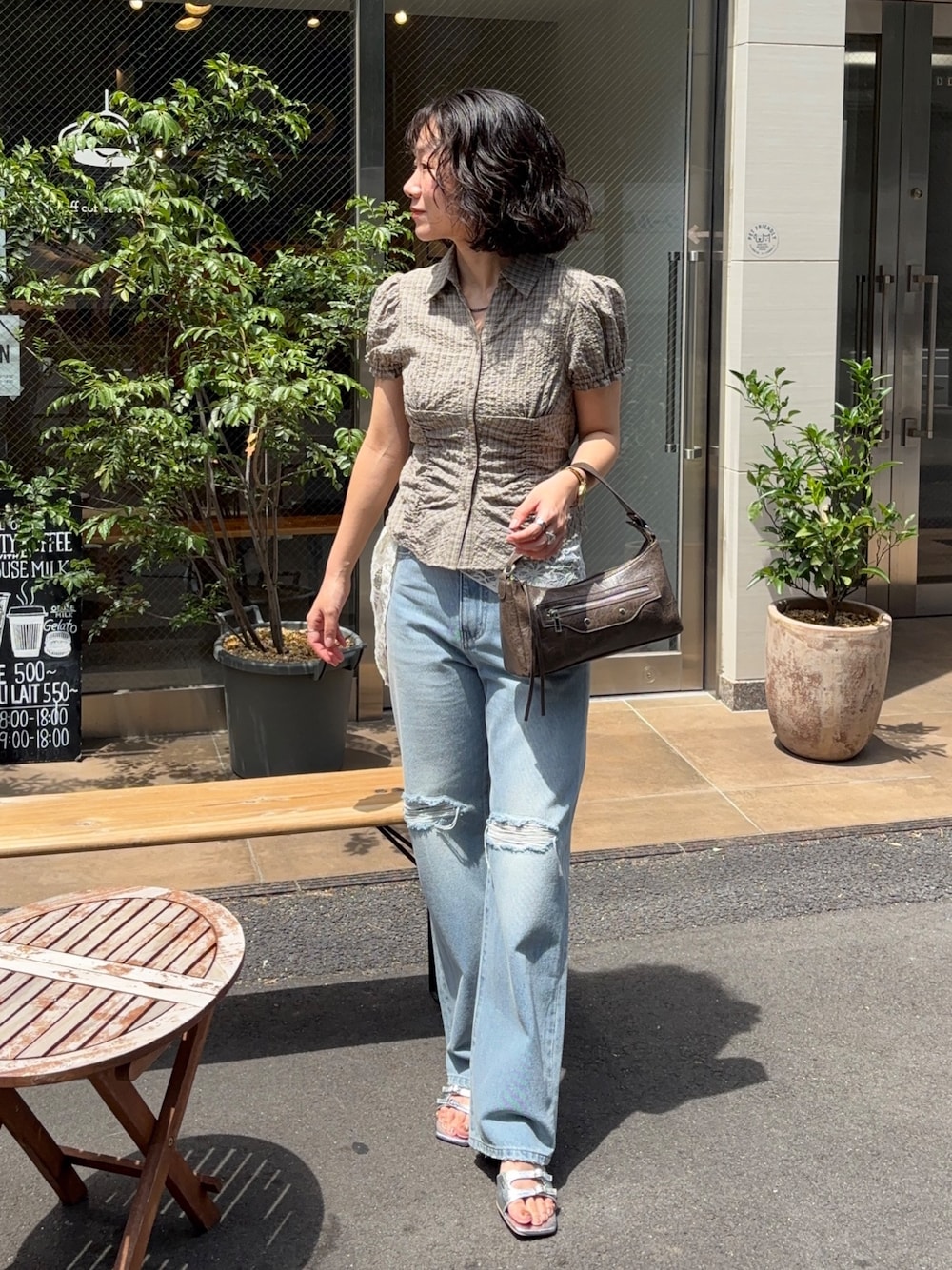 ベージュ系のシャツ/ブラウス、ブルー系のデニムパンツ、ブラウン系のショルダーバッグを着用したレディースの夏コーディネートの1枚目の写真