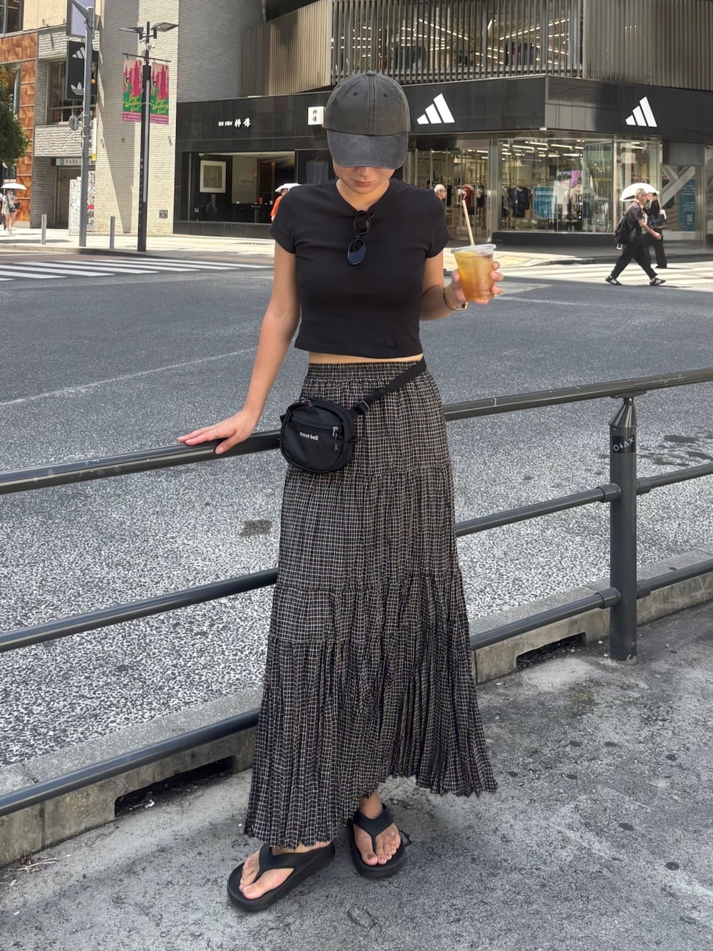 ブラック系のスカート、ブラック系のトップス、ブラック系のバッグを着用したレディースの夏コーディネートの1枚目の写真