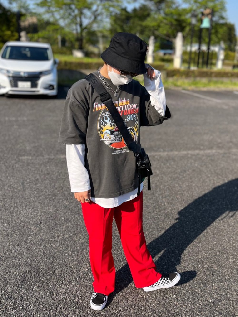 ブラック系のTシャツ/カットソー、ホワイト系のTシャツ/カットソー、レッド系のスラックスを着用したレディースの春コーディネートの1枚目の写真
