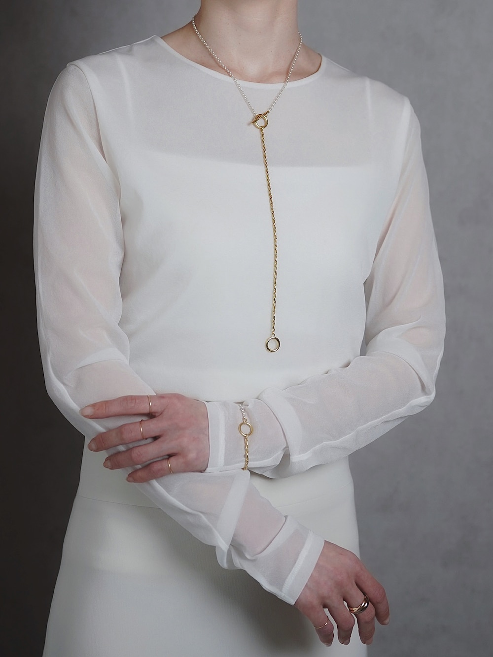 シルバー系のネックレス、シルバー系のブレスレット、ゴールド系のリングを着用したレディースの春コーディネートの1枚目の写真