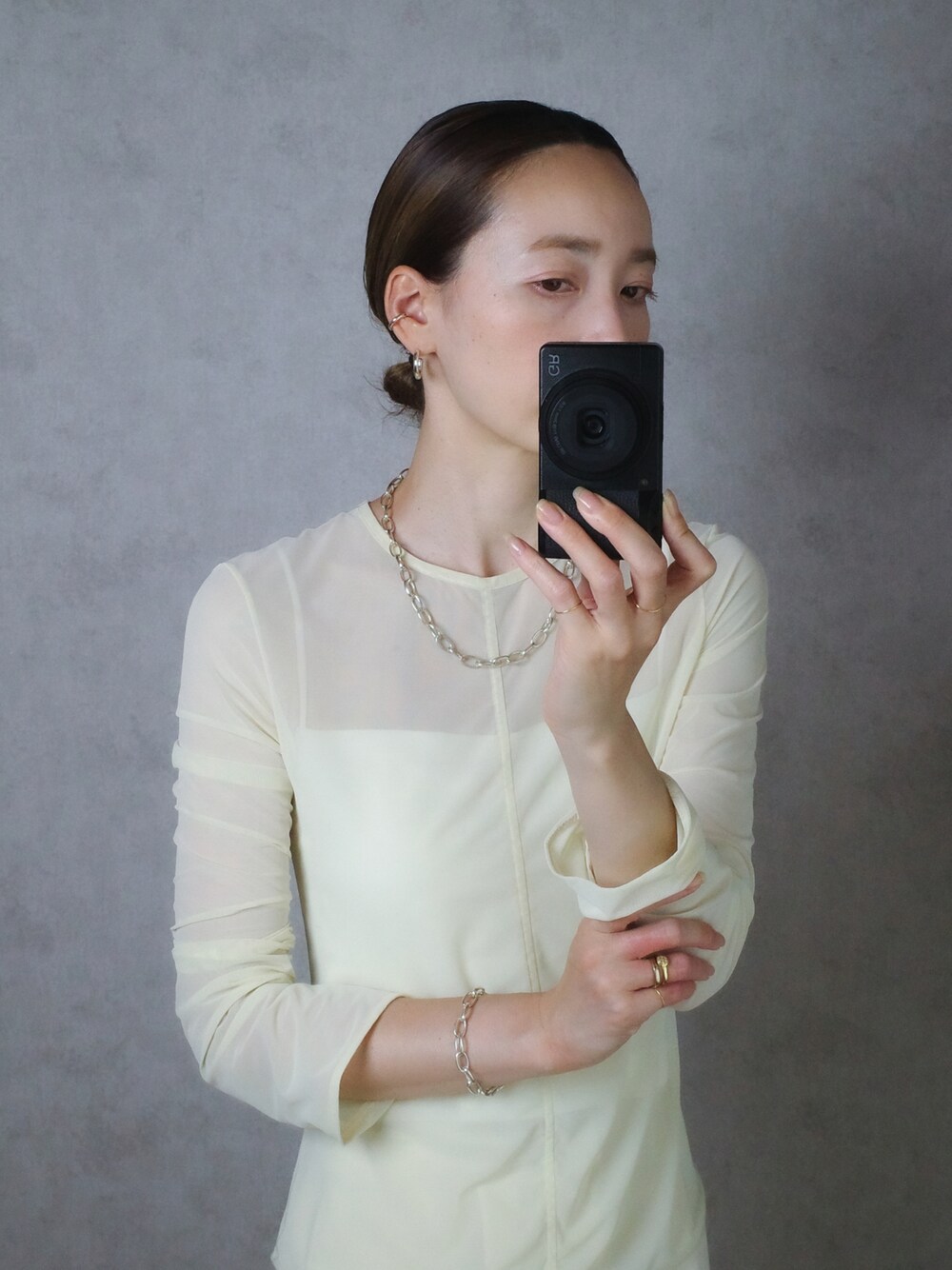 シルバー系のネックレス、シルバー系のブレスレット、ゴールド系のリングを着用したレディースの夏コーディネートの1枚目の写真