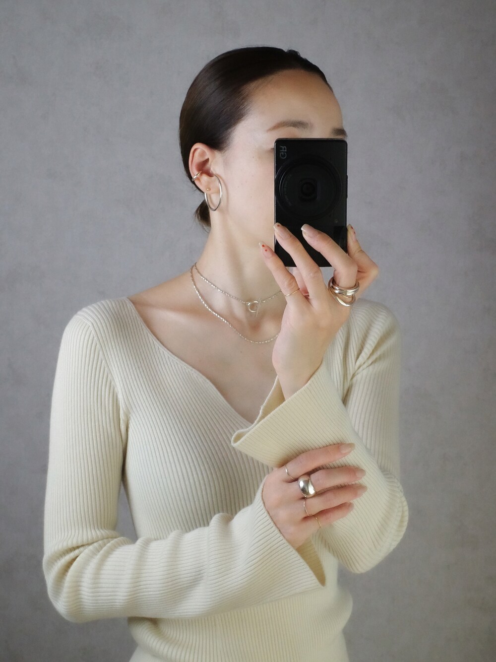 シルバー系のネックレス、シルバー系のリング、ゴールド系のリングを着用したレディースの秋コーディネートの1枚目の写真