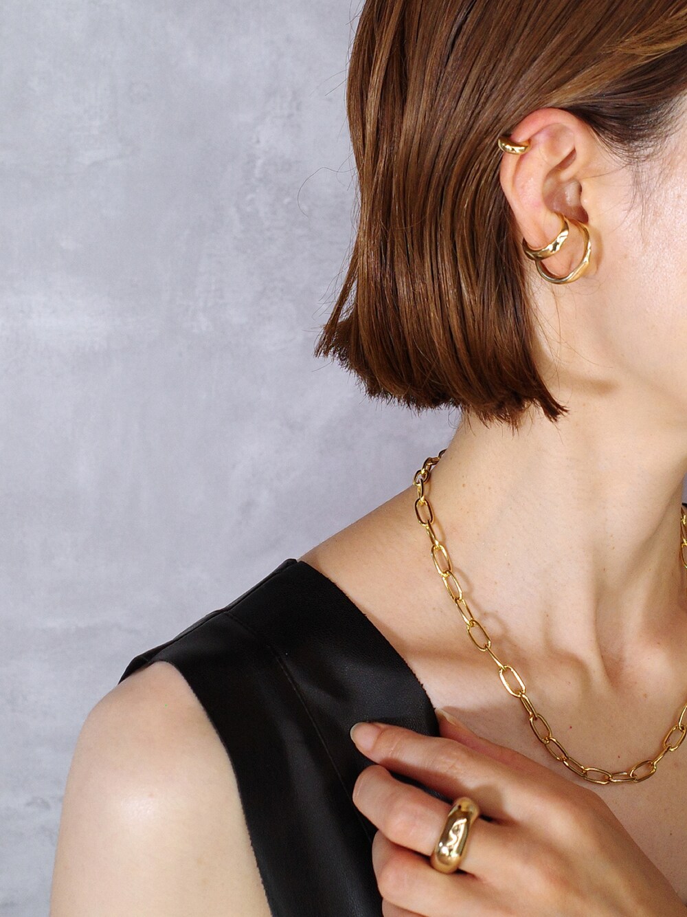 ゴールド系のネックレス、ゴールド系のイヤーカフ、シルバー系のイヤーカフを着用したレディースの夏コーディネートの1枚目の写真