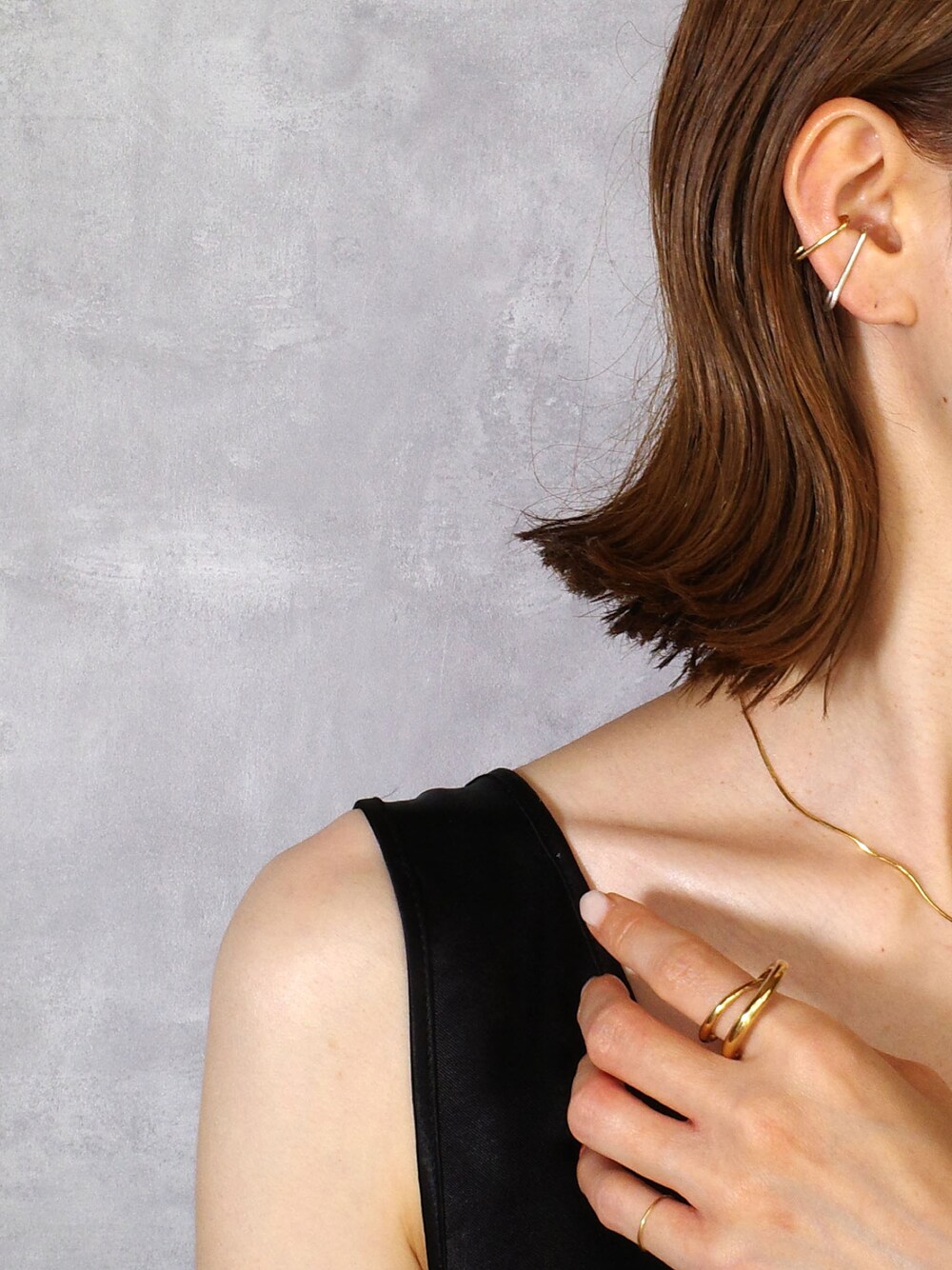 ゴールド系のイヤーカフ、シルバー系のイヤーカフ、ゴールド系のネックレスを着用したレディースの夏コーディネートの1枚目の写真