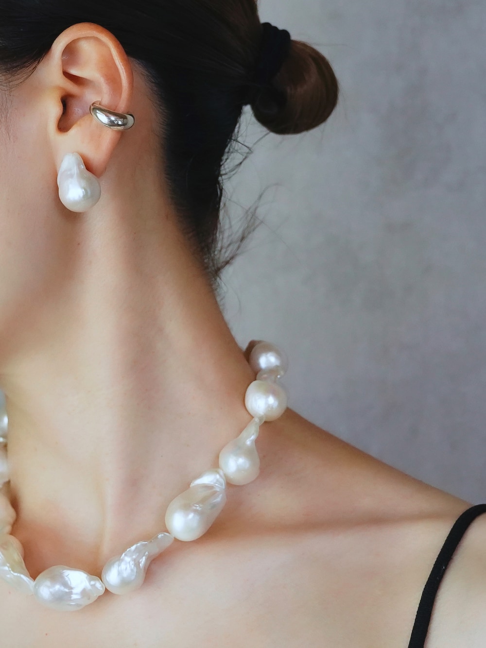 シルバー系のイヤーカフ、ホワイト系のネックレスを着用したレディースの夏コーディネートの1枚目の写真