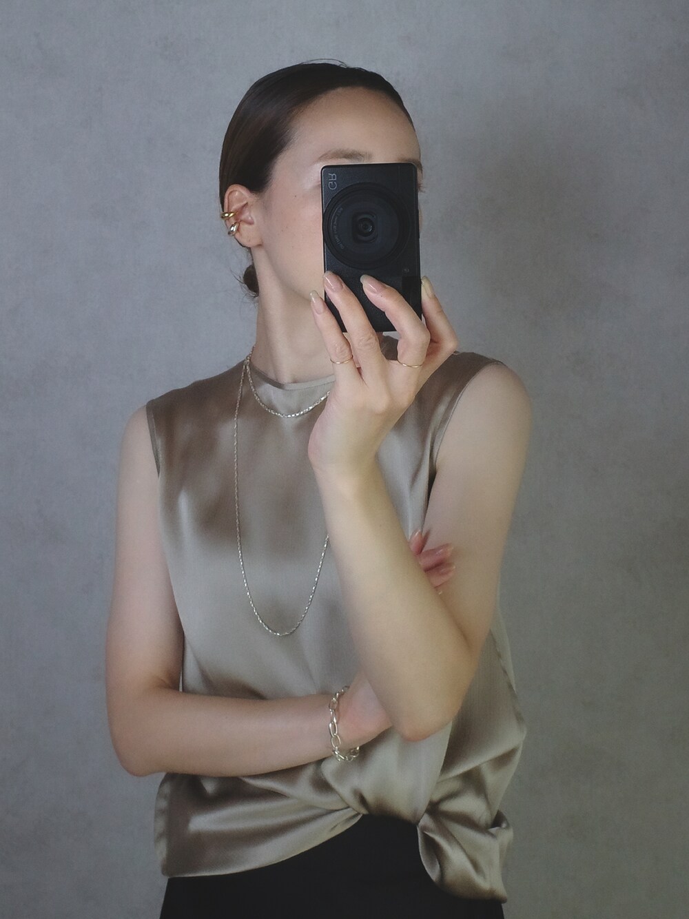 ゴールド系のトップス、シルバー系のネックレス、シルバー系のネックレスを着用したレディースの夏コーディネートの1枚目の写真