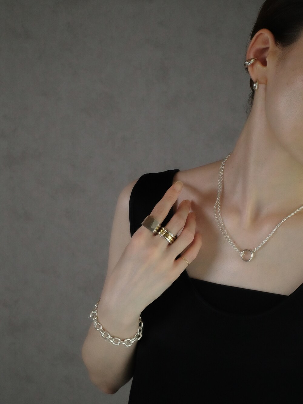 シルバー系のイヤーカフ、シルバー系のピアス（両耳用）、シルバー系のネックレスを着用したレディースの夏コーディネートの1枚目の写真