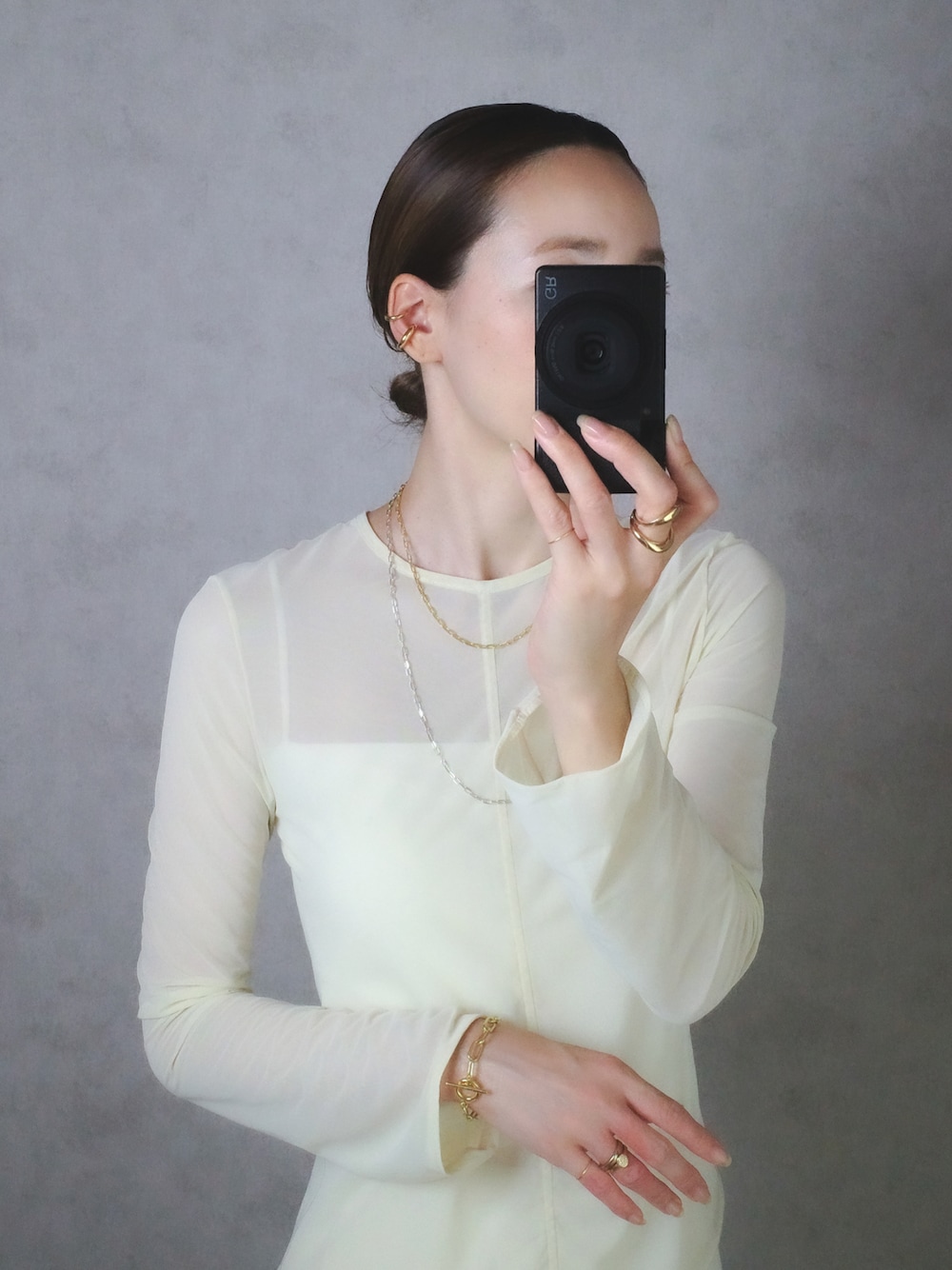 シルバー系のネックレス、ゴールド系のネックレス、ゴールド系のイヤーカフを着用したレディースの夏コーディネートの1枚目の写真