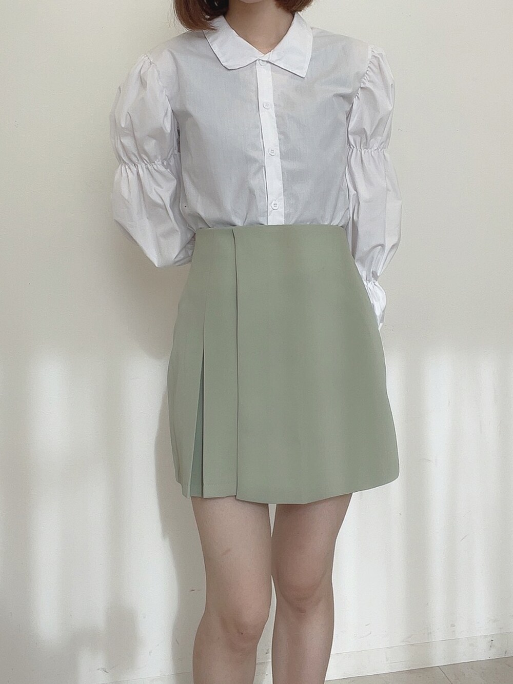 ホワイト系のシャツ/ブラウス、グリーン系のスカートを着用したレディースの冬コーディネートの1枚目の写真