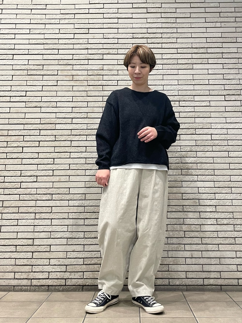 ブラック系のニット/セーター、ホワイト系のその他パンツを着用したレディースの秋コーディネートの1枚目の写真