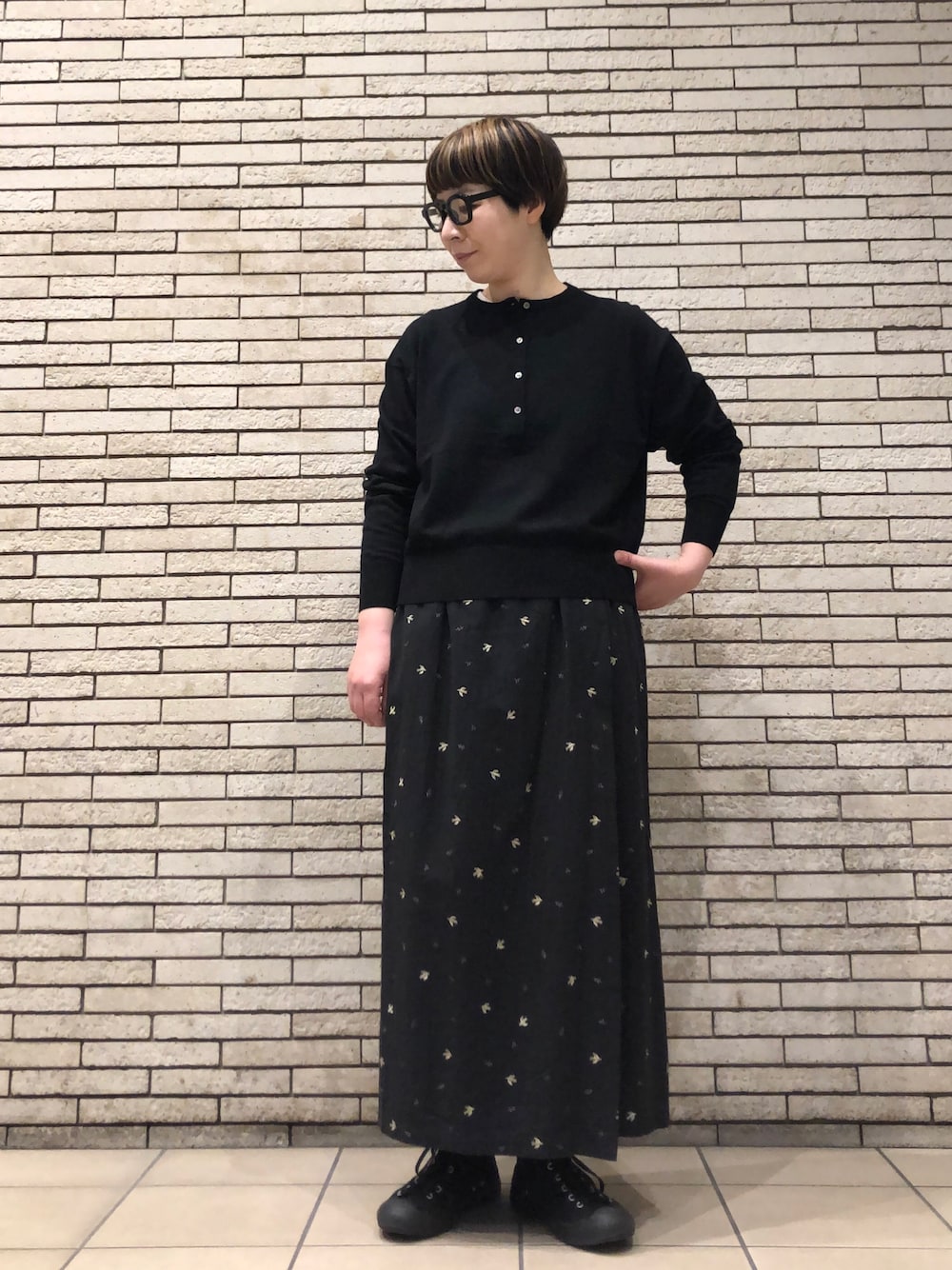 ブラック系のニット/セーター、ブラック系のスカートを着用したレディースの冬コーディネートの1枚目の写真