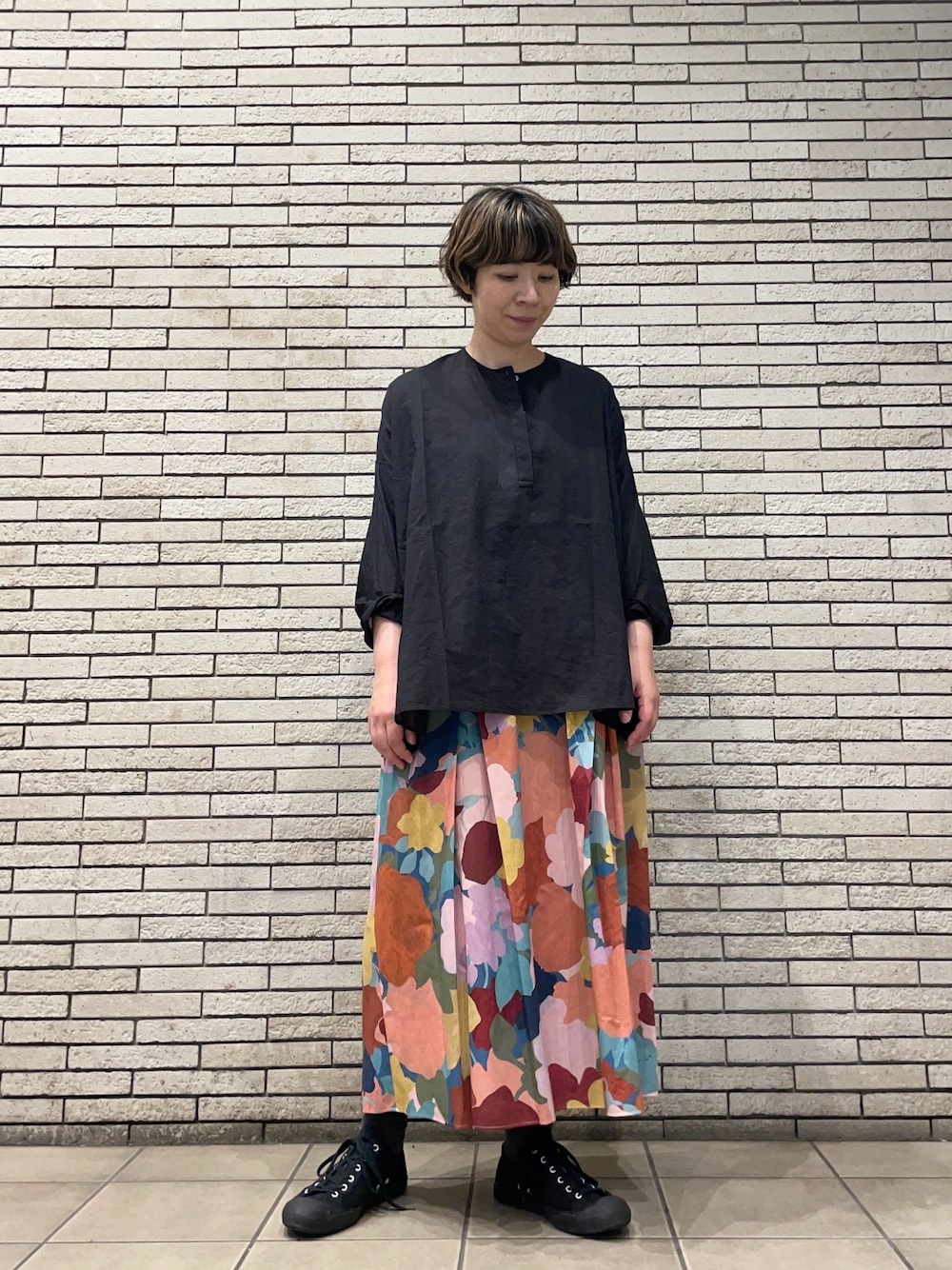 ブラック系のシャツ/ブラウス、ピンク系のスカートを着用したレディースの秋コーディネートの1枚目の写真