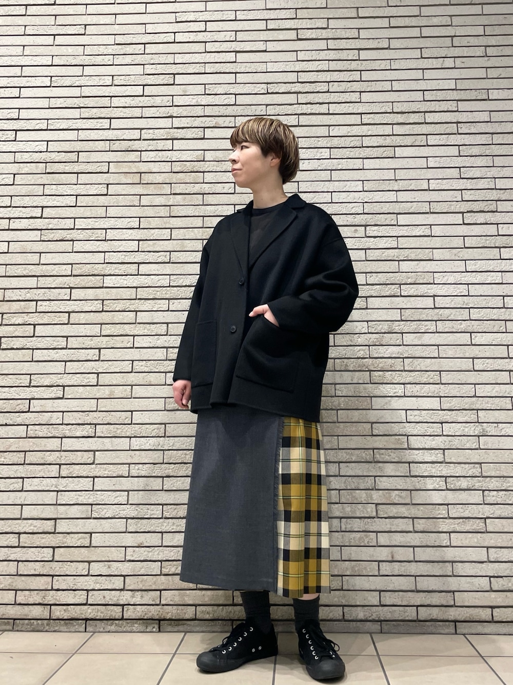 ブラック系のその他アウター、ベージュ系のスカートを着用したレディースの秋コーディネートの1枚目の写真