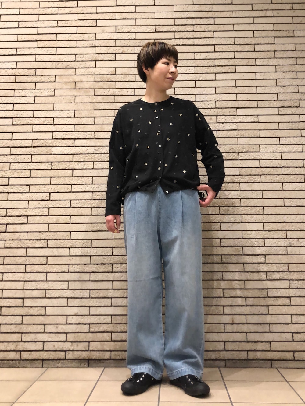 ブラック系のシャツ/ブラウス、ブルー系のデニムパンツを着用したレディースの冬コーディネートの1枚目の写真