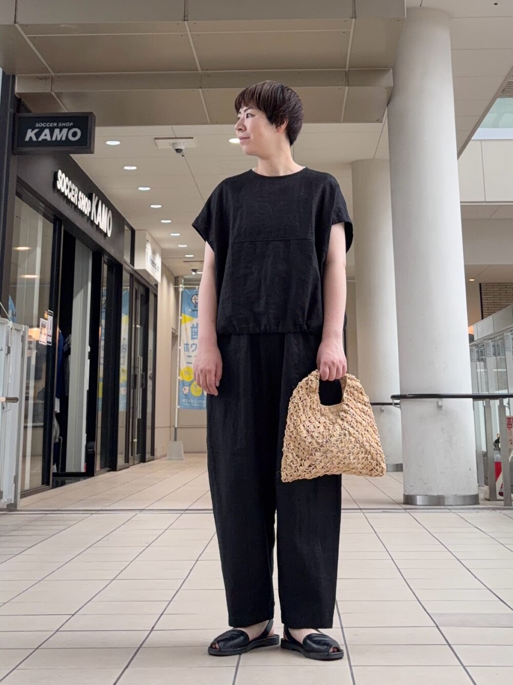 ブラック系のシャツ/ブラウス、ベージュ系のハンドバッグ、ブラック系のその他パンツを着用したレディースの夏コーディネートの1枚目の写真