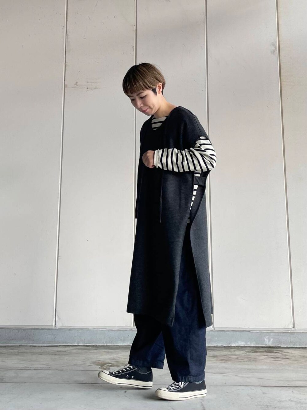 ブルー系のデニムパンツ、ホワイト系のTシャツ/カットソー、グレー系のワンピースを着用したレディースの秋コーディネートの1枚目の写真