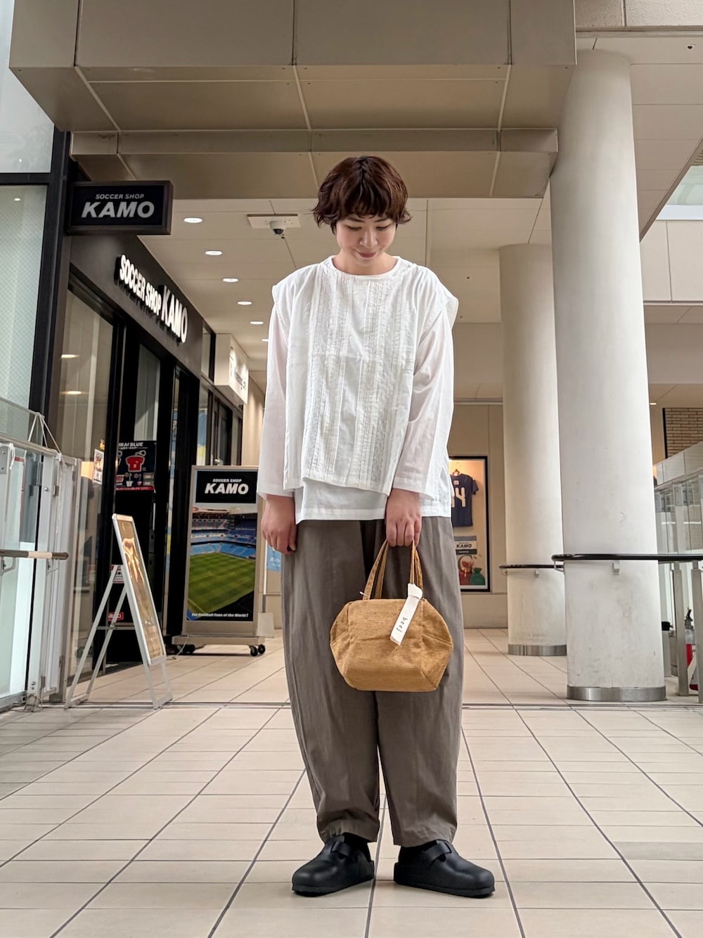 ホワイト系のシャツ/ブラウス、グリーン系のその他パンツ、イエロー系のハンドバッグを着用したレディースの秋コーディネートの1枚目の写真
