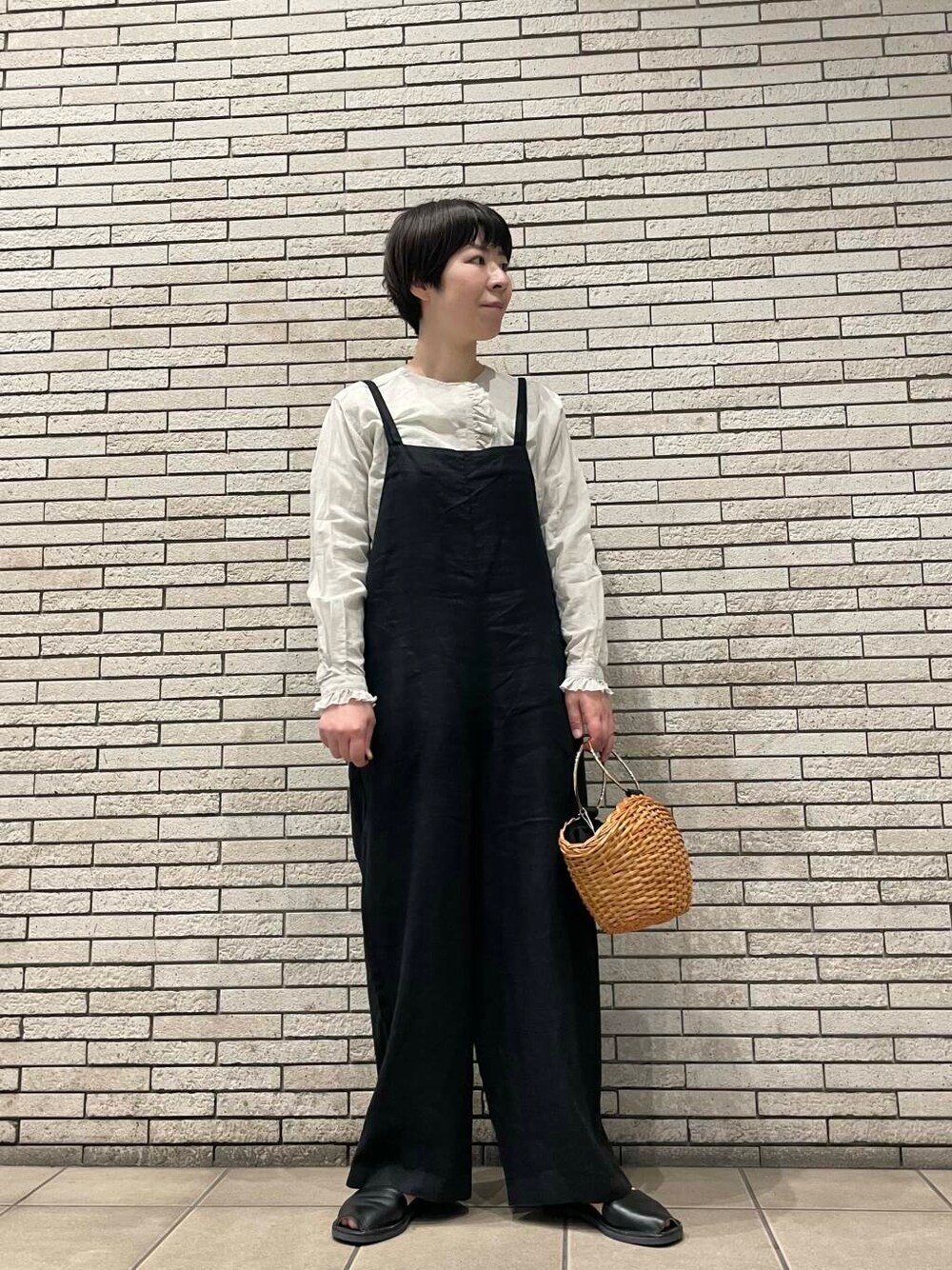 ブラック系のサロペット/オーバーオール、イエロー系のショルダーバッグ、グレー系のシャツ/ブラウスを着用したレディースの春コーディネートの1枚目の写真