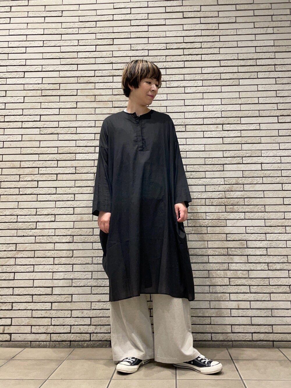 ブラック系のチュニック、ベージュ系のその他パンツを着用したレディースの夏コーディネートの1枚目の写真