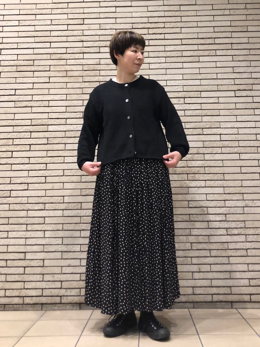 ブラック系のカーディガン/ボレロ、ブラック系のスカートを着用したレディースの冬コーディネートの1枚目の写真