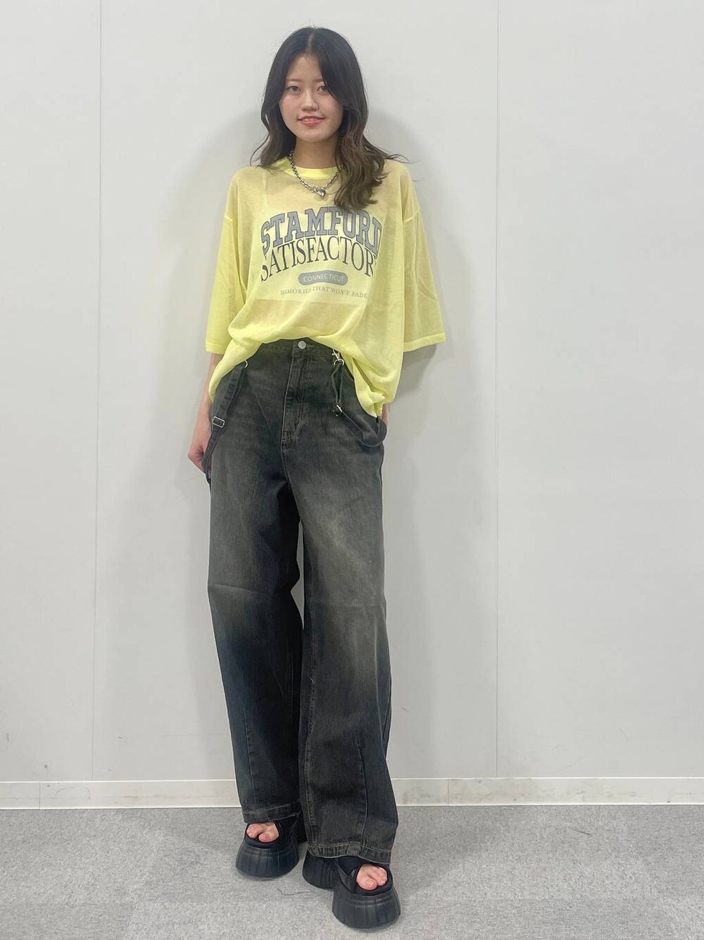 ブラック系のスニーカー、ブラック系のデニムパンツ、イエロー系のTシャツ/カットソーを着用したレディースの夏コーディネートの1枚目の写真