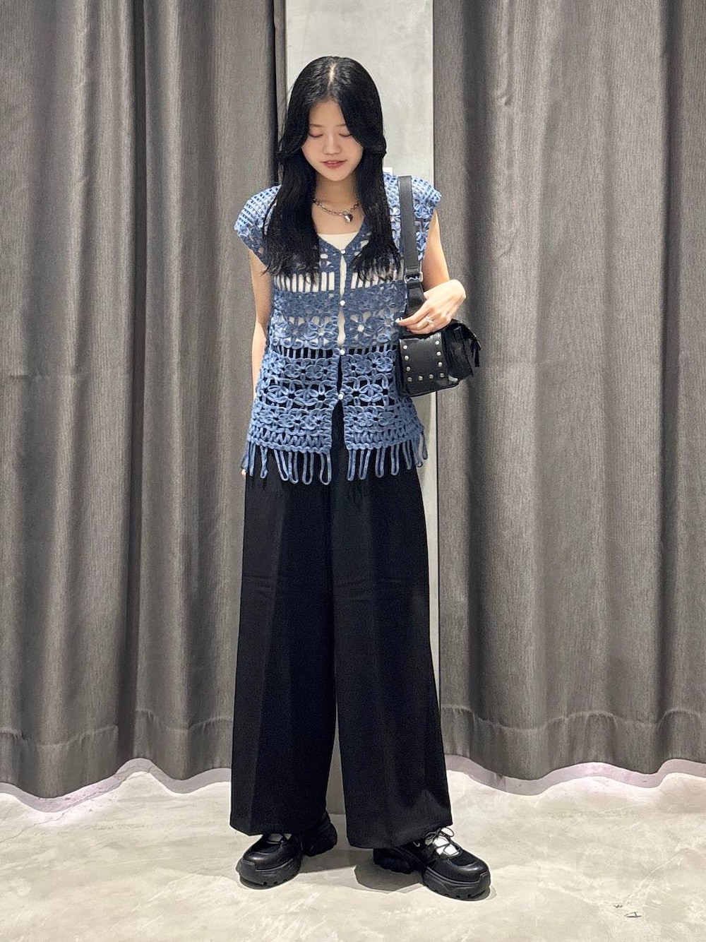 ホワイト系のタンクトップ、ブラック系のスラックス、ブルー系のベストを着用したレディースの夏コーディネートの1枚目の写真